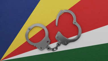 Yarı açık çelik kelepçe ortada ve Seyşeller bayrağının üstünde.