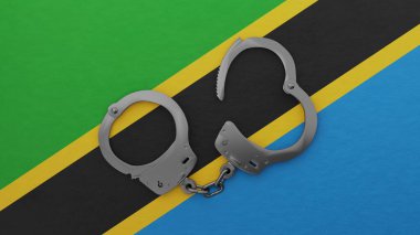 Yarı açık çelik kelepçeler ortada ve Tanzanya bayrağının tepesinde.