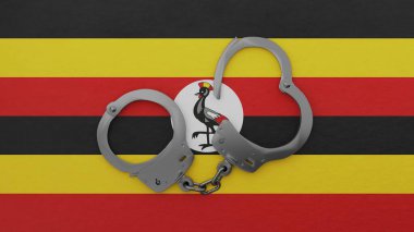 Yarı açık çelik kelepçeler ortada ve Uganda bayrağının tepesinde.