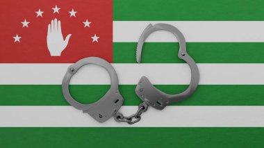 Yarı açık çelik kelepçe ortada ve Abhazya bayrağının üstünde.