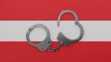 Yarı açık çelik kelepçeler ortada ve Avusturya bayrağının tepesinde.