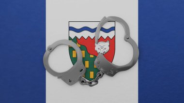 Yarı açık çelik kelepçeler ortada ve Kuzeybatı Bölgesi bayrağının tepesinde.