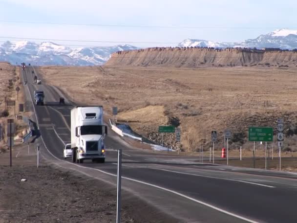 A semi- truck moves along a highway through the Rocky Mountains — Stock Video