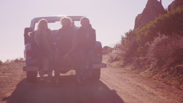 Amigos se sientan en el camión mientras conduce a lo largo de un camino rural — Vídeos de Stock