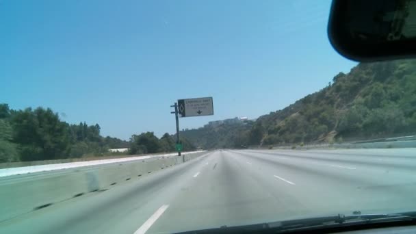 Машина едет по пустому участку автострады в Лос-Анджелесе со строительными машинами, видимыми в закрытых полосах слева . — стоковое видео