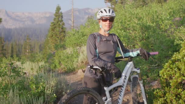 Górski stoi z nią na rowerze w pobliżu lasu — Wideo stockowe