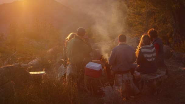 Een groep van vriend stand rond een kampvuur — Stockvideo