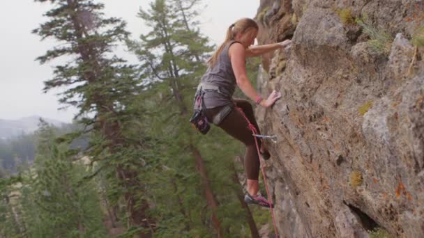 Escalador escalando una pared de roca pura — Vídeo de stock