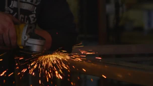 Sparks terbang sebagai pinggiran pekerja dengan alat di bengkel — Stok Video