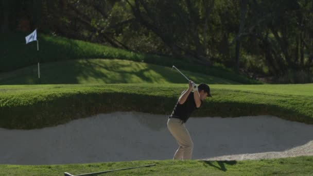 Ένας παίκτης γκολφ παίρνει μια στροφή σε μιας παγίδας άμμου σε μια σειρά μαθημάτων γκολφ — Αρχείο Βίντεο