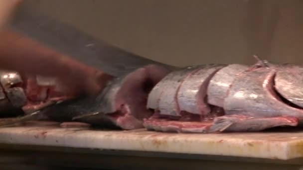 Um açougueiro corta peixe fresco num mercado . — Vídeo de Stock