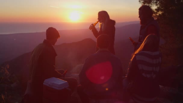Друзья пьют пиво в кемпинге на закате — стоковое видео