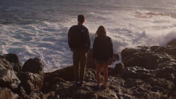 Casal fica em uma costa rochosa — Vídeo de Stock