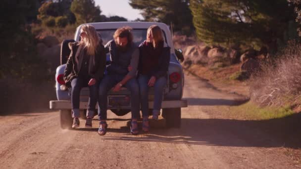 Amigos se sientan en el camión mientras conduce a lo largo de un camino rural — Vídeos de Stock