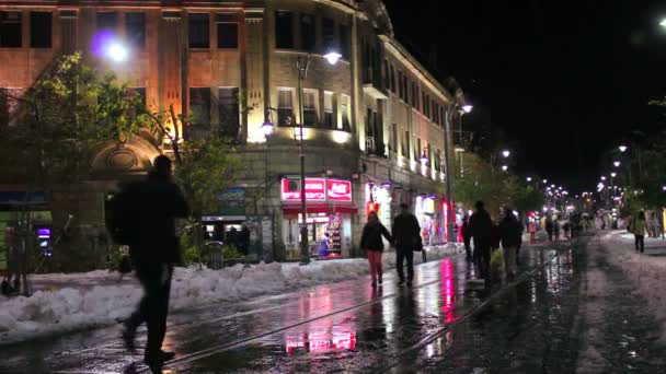 Människor går genom snöiga gator i Jerusalem på natten — Stockvideo