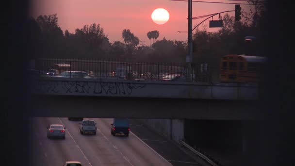 Matahari terbenam di atas jalan bebas hambatan pada hari berkabut berkabut di Los Angeles — Stok Video