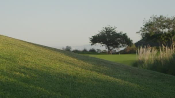 Colina sobre olhando um campo de golfe — Vídeo de Stock