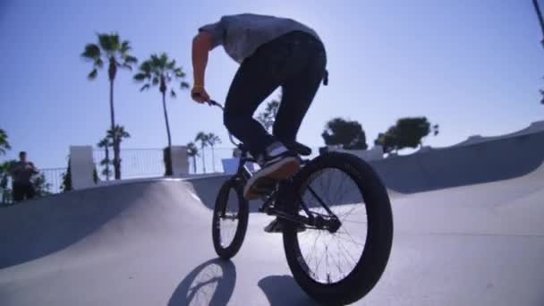 BMX pyöräilijä ratsastaa seinään skatepark — kuvapankkivideo