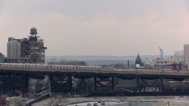 Un train surélevé passe avec la Statue de la Liberté visible — Video