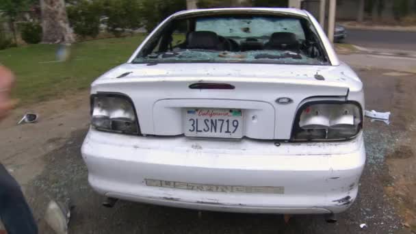 Человек уничтожает свой автомобиль — стоковое видео