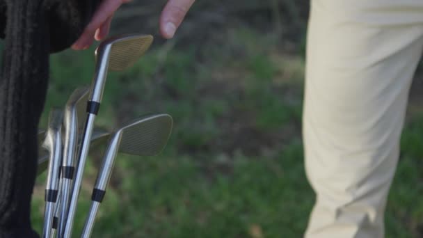 Golfer pulling a club from his bag — Stock Video