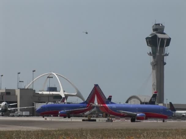 Aviones taxi a lo largo de la pista en el Aeropuerto Internacional de Los Ángeles — Vídeos de Stock