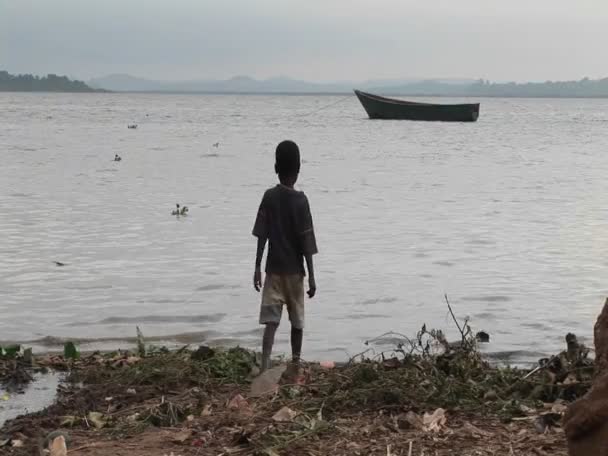Мальчик играет на берегу озера Виктория — стоковое видео