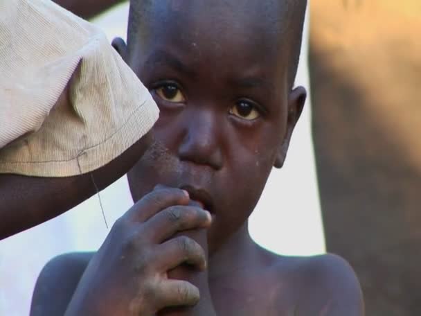 Παιδί αγγίζει τα δάχτυλά του στο στόμα του σε στρατόπεδο — Αρχείο Βίντεο