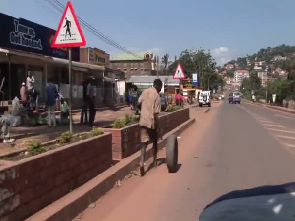 Hombre que viaja a lo largo de una carretera ocupada en África — Vídeos de Stock