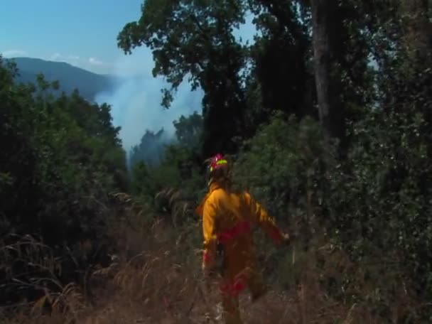 Un bombero camina por la tierra — Vídeos de Stock