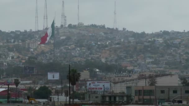 Mexikanska flaggan ses vinka över downtown Tijuana — Stockvideo