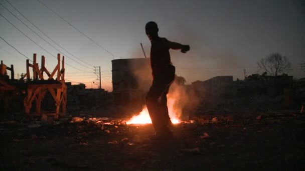 En man dansar framför en eld. — Stockvideo