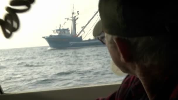 Um homem olha pela janela de um barco — Vídeo de Stock