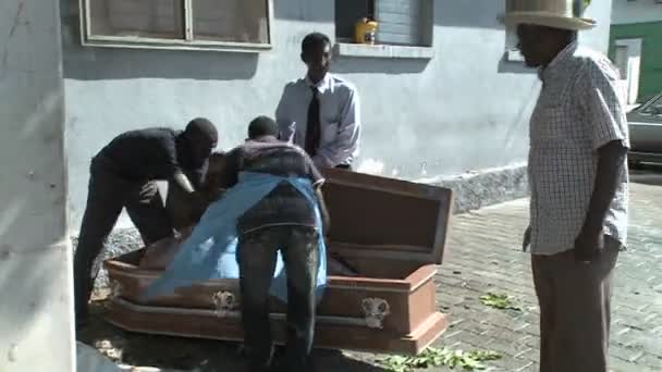 A victim of the Haiti earthquake is loaded into a coffin — Stock Video