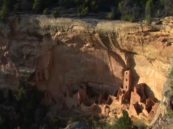 Une falaise s'élève au-dessus des habitations indiennes Pueblo — Video