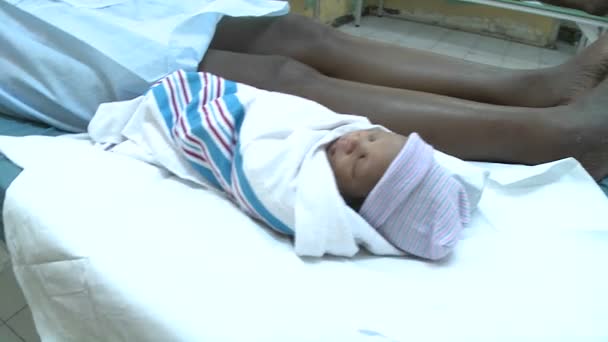 Μια τραυματισμένη γυναίκα βρίσκεται σε ένα κρεβάτι του νοσοκομείο με το μωρό — Αρχείο Βίντεο