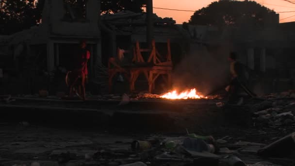 La gente camina alrededor de un fuego abierto — Vídeos de Stock