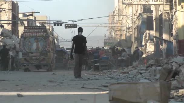 Mensen lopen door de verwoeste straten van Haïti — Stockvideo