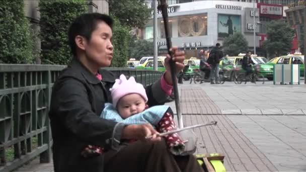Un ciego toca música en una calle — Vídeos de Stock