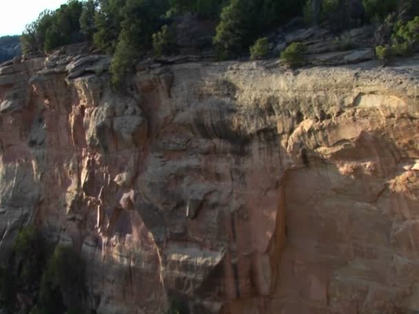 Une falaise s'élève au-dessus des habitations indiennes Pueblo — Video