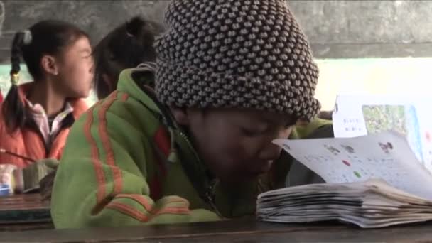 Children practice writing in a rural classroom — Stock Video
