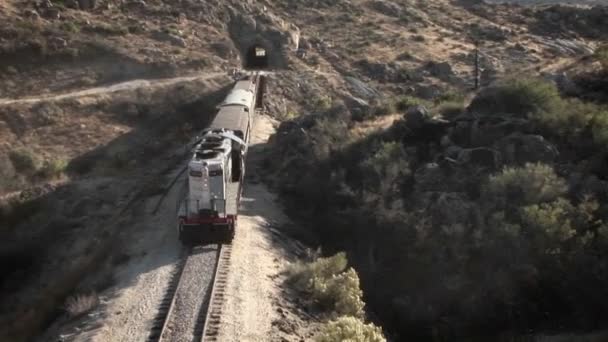 Un tren comienza a entrar en un túnel — Vídeos de Stock