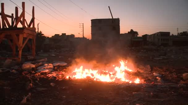 Открытый огонь горит в суровом районе — стоковое видео