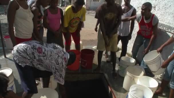 Люди получают воду из колодца после сильного землетрясения — стоковое видео