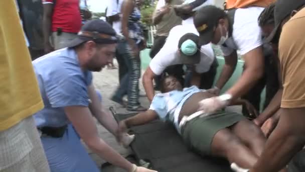 Een slachtoffer wordt van een brancard verplaatst tijdens de aardbeving — Stockvideo