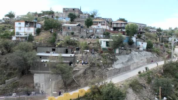 La gente camina alrededor de un grupo de casas — Vídeos de Stock