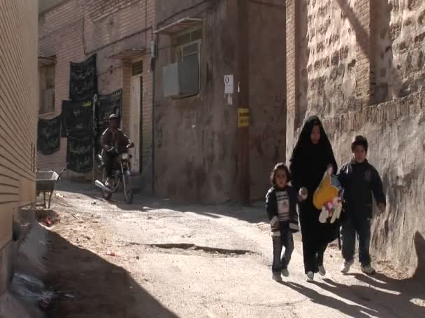 Une femme marche avec deux enfants dans une ancienne ruelle — Video