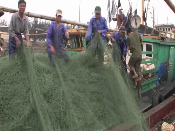 Männer sammeln Fischernetze von einem Boot — Stockvideo