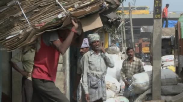 Werknemer een stapel van karton draagt op zijn rug en geladen op een vrachtwagen — Stockvideo