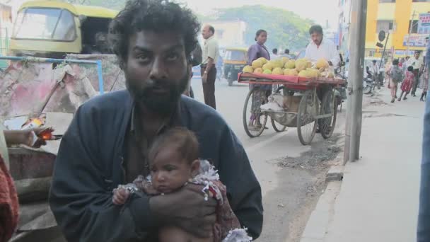 Мужчина держит ребенка на индийской улице — стоковое видео